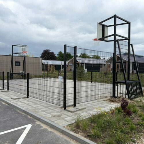 Pannakooi met basketbal 88 Maatwerk pannakooi 7,5 x 12,5 meter in Yerseke Zeeland met zwarte coating, geluidsarme basketbalborden, rode basketbalringen en geïntegreerde voetbaldoelen op bestaande tegelvloer